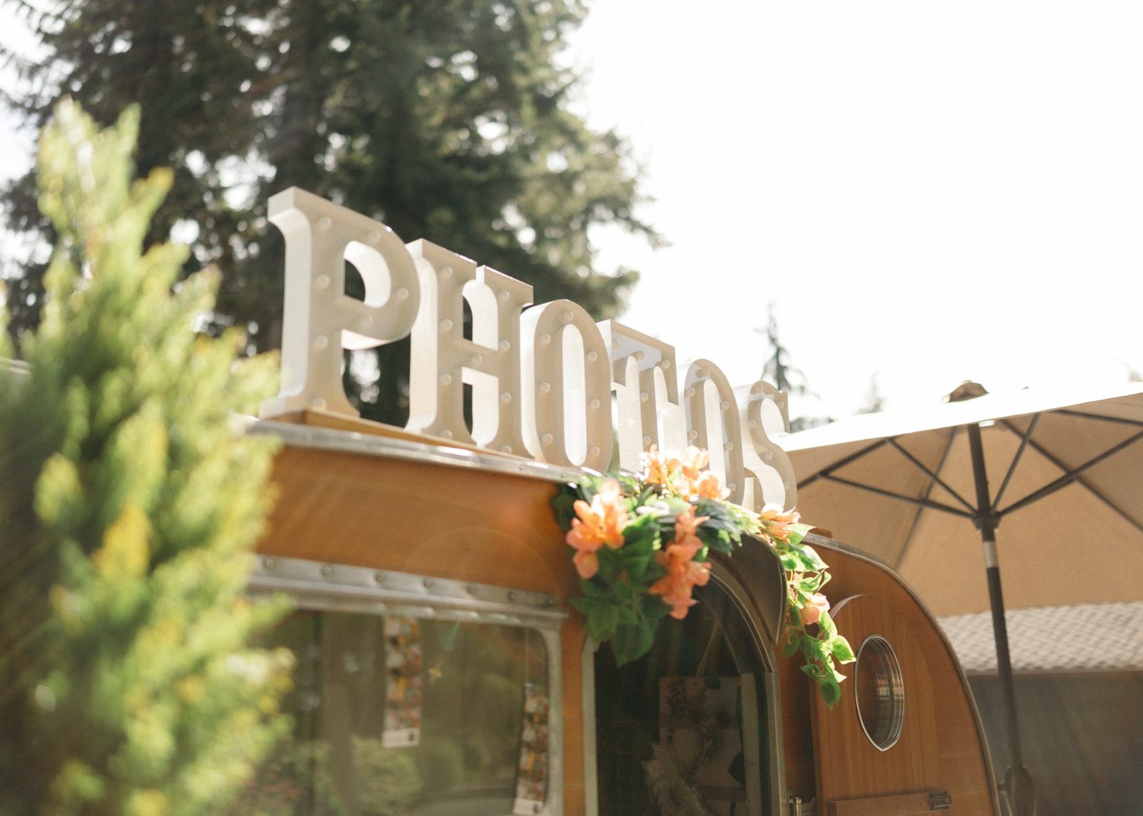 The PHOTOS marquee sign on top of the trailer, with flowers around the door