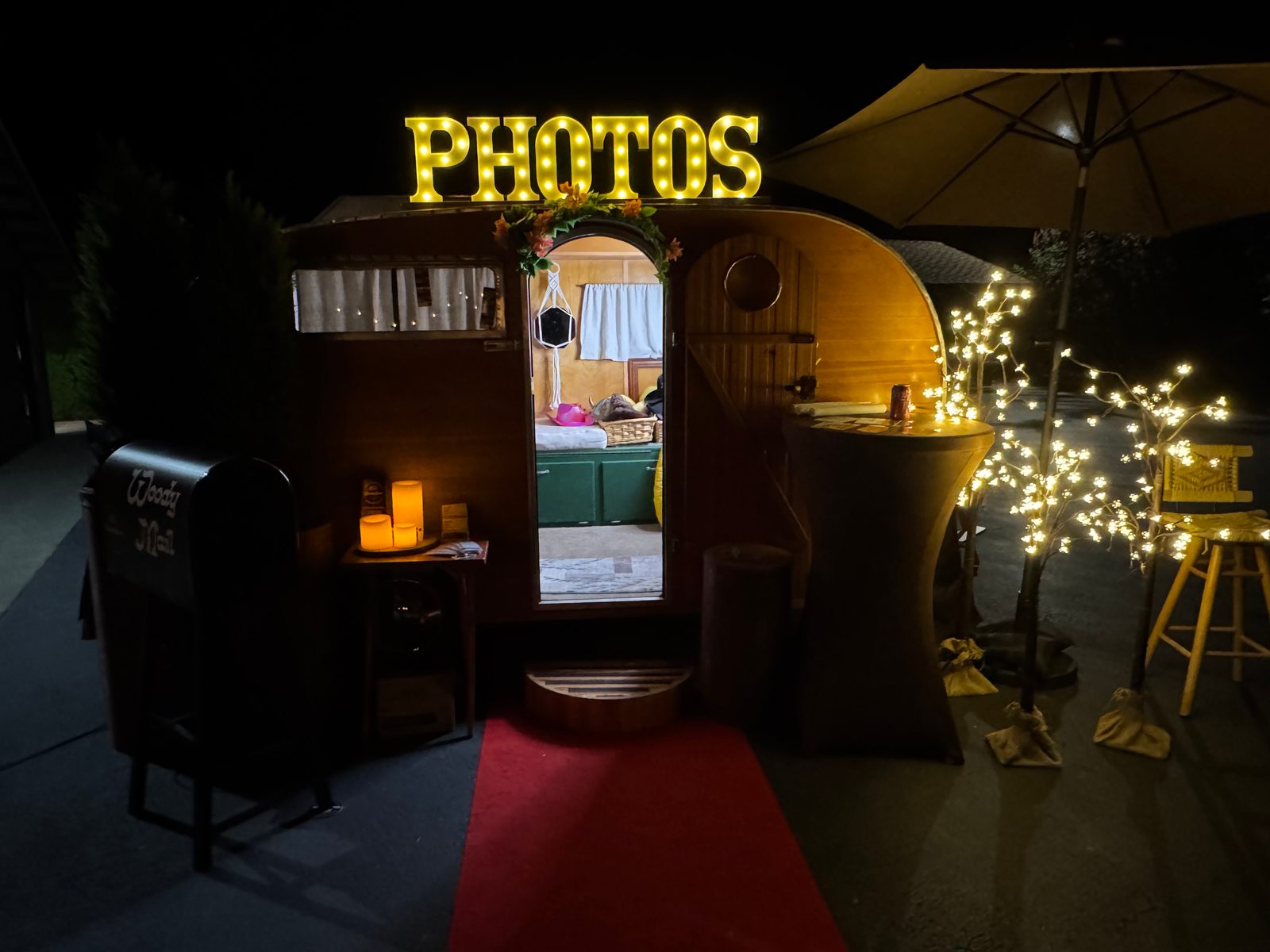 The trailer glowing at night with the lit PHOTOS sign